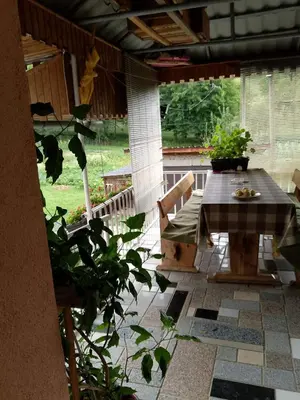 a patio with a table and chairs on a porch at Secret garden in Visoko
