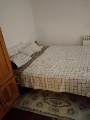 a small bedroom with a bed with white sheets at Secret garden in Visoko