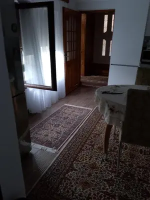 a room with a table and a door and a rug at Secret garden in Visoko