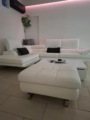 a living room with white couches and a table at Mansarda Apartman Diva in Prijedor