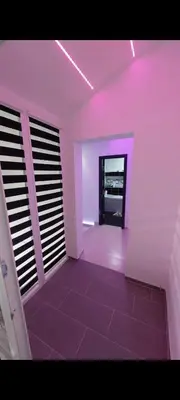 a room with purple lighting and a room with a hallway at Mansarda Apartman Diva in Prijedor