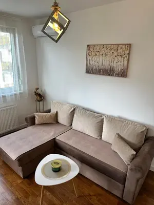 a living room with a couch and a table at Stan na dan Banja Luka DM in Ivišovo Greblje