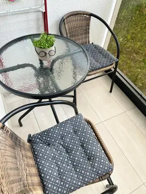 a glass table with two chairs and a potted plant at Stan na dan Banja Luka DM in Ivišovo Greblje