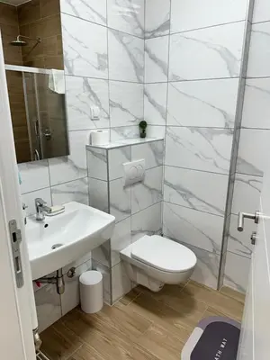 a white bathroom with a toilet and a sink at Stan na dan Banja Luka DM in Ivišovo Greblje
