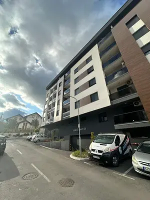 a parking lot with cars parked in front of a building at Stan na dan Banja Luka DM in Ivišovo Greblje