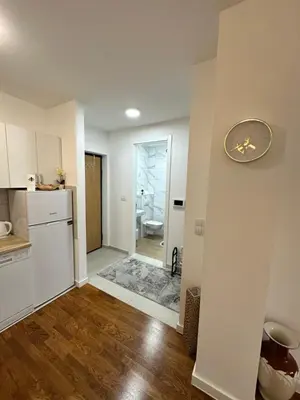 a kitchen with white cabinets and a clock on the wall at Stan na dan Banja Luka DM in Ivišovo Greblje