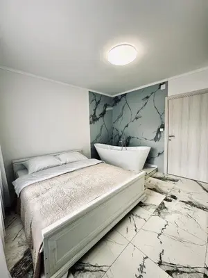 a bedroom with a large bed and a marble wall at Apartment Casa Deluxe in Visoko