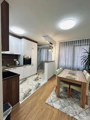 a kitchen and living room with a wooden table and a dining room at Apartment Casa Deluxe in Visoko