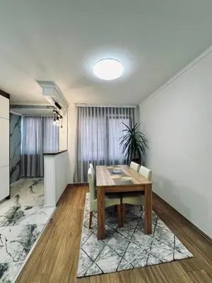 a dining room with a wooden table and chairs at Apartment Casa Deluxe in Visoko