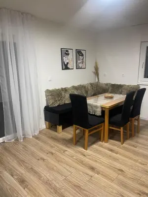 a living room with a table and chairs and a couch at Sašina kuća in Livno