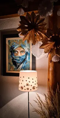a lamp in front of a painting and a picture at Planinska kuća 