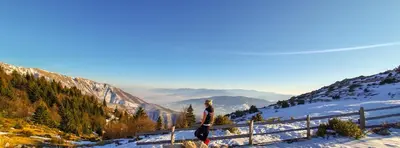 a woman standing on top of a snow covered mountain at Planinska kuća 