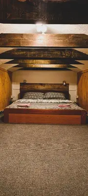 a bed in a bedroom with a wooden frame at Planinska kuća 