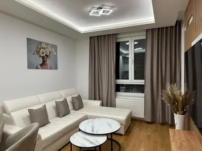 a living room with a white couch and a table at GRAĐUS Deluxe Apartmani in Kotor-Varoš
