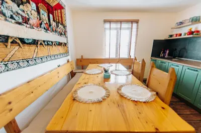 a dining room with a wooden table with plates on it at Kuća s osmijehom in Livno