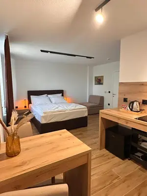 a bedroom with a bed and a couch and a table at Hotel Fortuna in Gradačac