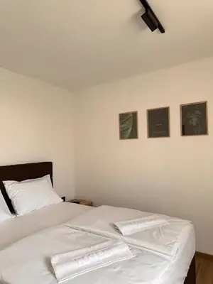 a bedroom with two beds and three pictures on the wall at Hotel Fortuna in Gradačac