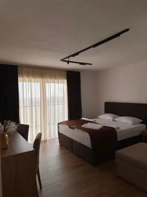 a bedroom with a bed and a table and a couch at Hotel Fortuna in Gradačac
