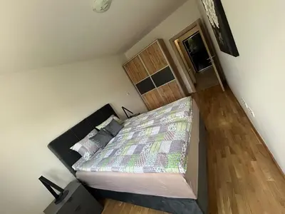 a small bedroom with a bed and a wooden floor at Apartment ALINA in Visoko