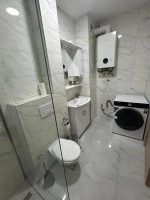 a white bathroom with a toilet and a shower at Apartment ALINA in Visoko