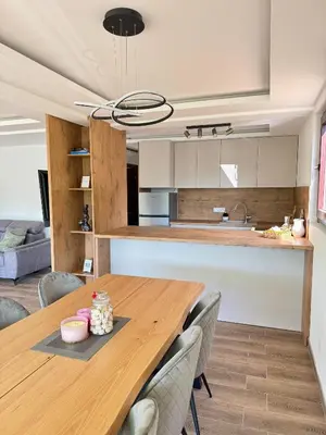 a kitchen and dining room with a wooden table and chairs at Villa Emilija Krupa na Vrbasu