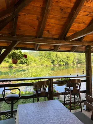 a porch with chairs and a table and a view of a river at Villa Emilija Krupa na Vrbasu