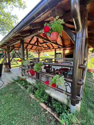 a wooden pergola with tables and flowers on it at Villa Emilija Krupa na Vrbasu