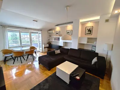 a living room with a black couch and a table at Sunny River BL in Banja Luka