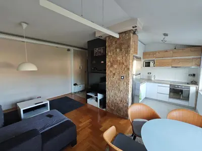 a living room with a blue couch and a kitchen at Sunny River BL in Banja Luka