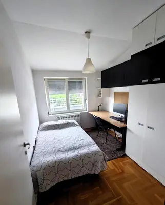a bedroom with a bed and a desk with a computer at Sunny River BL in Banja Luka