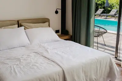 a bed in a bedroom with a view of a pool at Villa Alma Nova in Laktaši