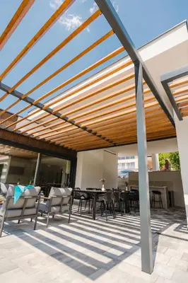a pergola with tables and chairs on a patio at Villa Alma Nova in Laktaši