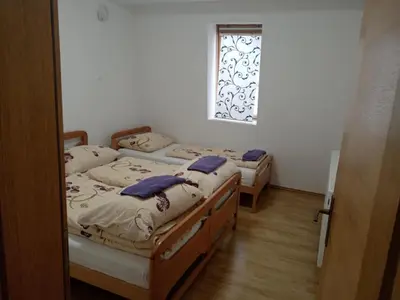 two beds in a room with a window at Vlašić Vacation apartment in Vlasic
