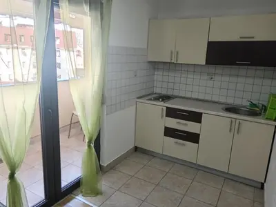 a small kitchen with white cabinets and a sink at Vlašić Vacation apartment in Vlasic