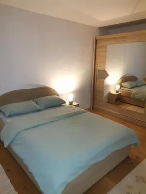 a bedroom with a large bed with two lamps at Kuća na dan in Bosansko Grahovo