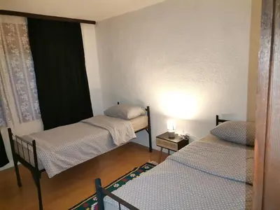 a small room with two beds and a window at Kuća na dan in Bosansko Grahovo