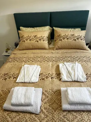 a bed with two pillows and two towels on it at Apartman Sara in Teslić