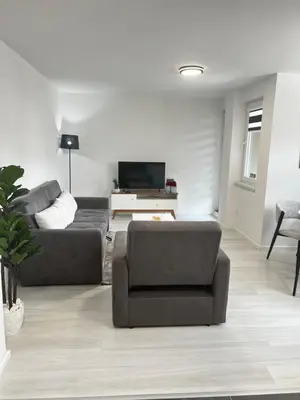 a living room with a couch and a tv at Apartman Sara in Teslić