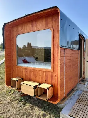 a small wooden house with a large window at Petrovf Place