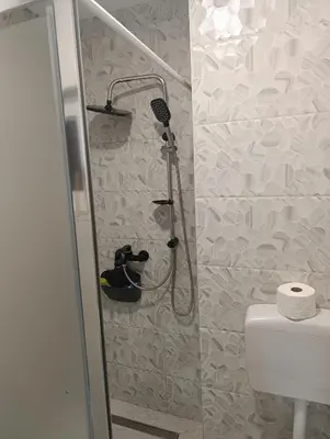 a shower in a bathroom with a toilet and a shower at Apartman ARDA in Jajce