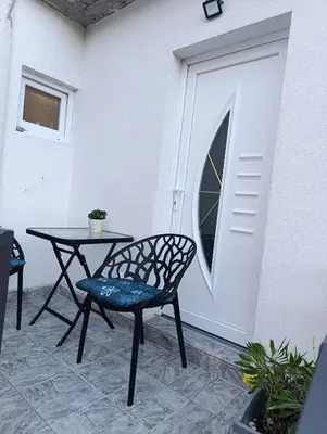a patio with a table and chairs next to a door at Apartman ARDA in Jajce