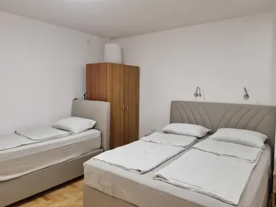 a bedroom with two beds and a wooden cabinet at Palada apartment in Banja Luka
