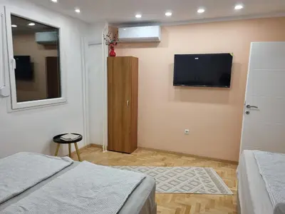 a bedroom with a bed and a flat screen tv on the wall at Palada apartment in Banja Luka