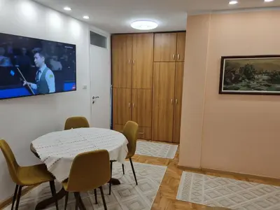 a room with a table and chairs and a tv at Palada apartment in Banja Luka