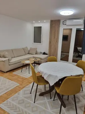 a living room with a table and chairs and a couch at Palada apartment in Banja Luka