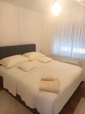 a bedroom with a white bed with two towels on it at Galija in Tomislavgrad