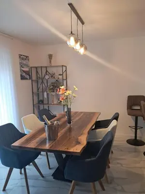 a dining room table with chairs and a vase of flowers on it at Galija in Tomislavgrad