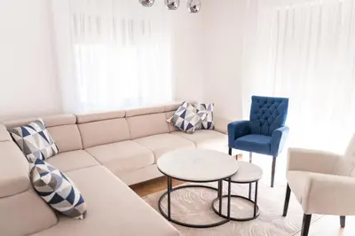 a living room with a white couch and a blue chair at Galija in Tomislavgrad