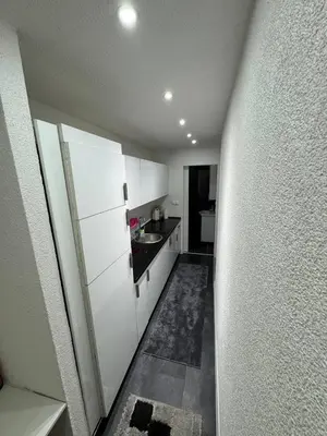 a small kitchen with white cabinets and a sink at Luxury Apartman Dzafic in Sanski most
