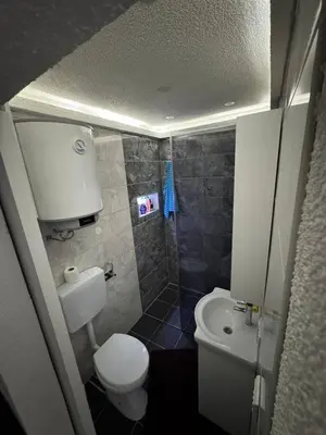 a small bathroom with a toilet and a shower at Luxury Apartman Dzafic in Sanski most